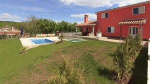 A red villa with a swimming pool, a patio, and a well-maintained lawn. - Villa Marina (Istria - Paradiž) (Paradiž)