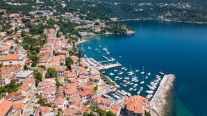 An aerial view of a coastal town with a marina filled with boats, surrounded by residential buildings with red-tiled roofs. - Villa Vista (Kvarner - Opatija) (Opatija)
