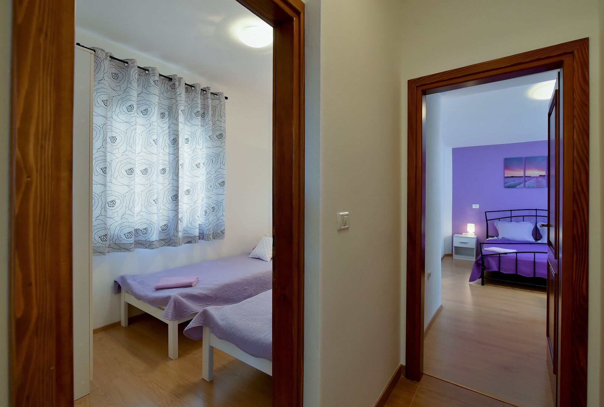 A bedroom with a single bed, a nightstand, and a bedside table.