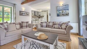 A cozy living room with two sofas, a coffee table, and a dining area.