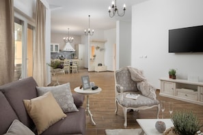 Relax in this inviting living space with a comfortable sofa, plush armchair, and flat-screen TV.