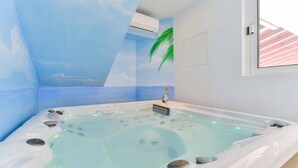 A spa room with a hot tub, a ceiling mural, and a window with blinds.