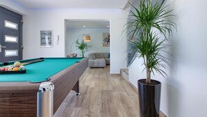 A modern living room with a pool table, a grey sofa, and a potted plant. - Villa LUKA (Istria - Loborika) (Loborika)
