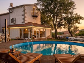 A pool area with wooden deck chairs, a pool, and a building with a balcony. - Villa NEVIA (Istria - Ripenda Verbanci) (Ripenda Verbanci)