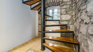 A spiral staircase with wooden steps and black metal railings in a room with stone walls and wooden flooring. - Villa NEVIA (Istria - Ripenda Verbanci) (Ripenda Verbanci)