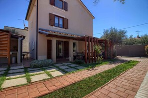 Relax in a spacious two-story house with a covered patio and beautifully maintained garden.