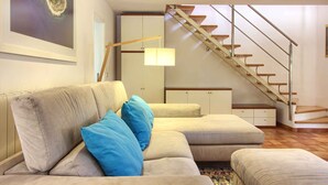 A living room with a beige sofa, blue cushions, a staircase, and a framed picture on the wall. - Villa Donatella (Istria - Sisan) (Sisan)