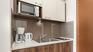 A kitchenette with a microwave, coffee maker, and sink. - Charming Studio with Balcony | Parking | Close to the Beach (Świnoujście)