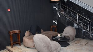 A modern lobby with a marble staircase, plush seating, and a stylish pendant light. - Cadé Hotel (Casablanca)