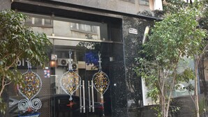 A hotel restaurant with a glass facade, potted plants, and a sign above the entrance. - Cadé Hotel (Casablanca)