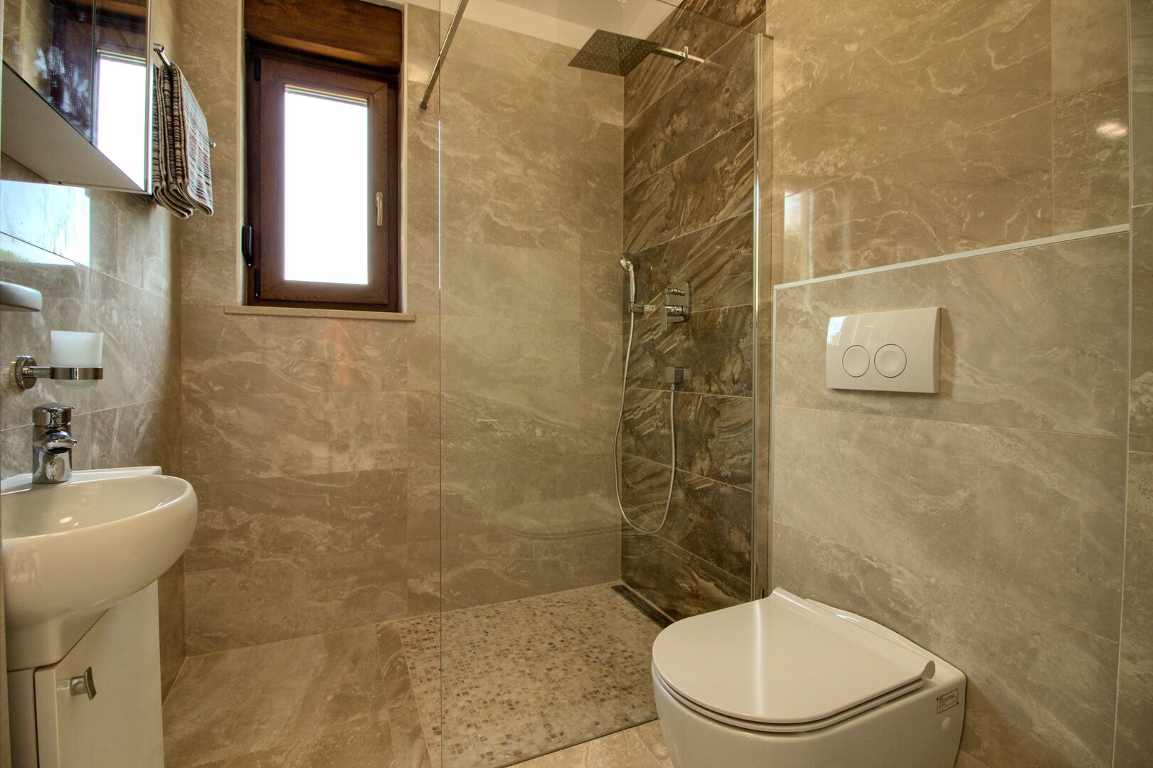 Une salle de bain équipée d’un lavabo, de toilettes et d’une douche.