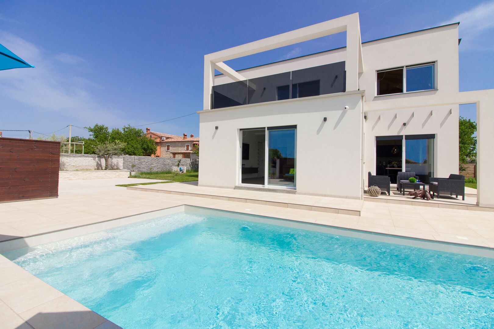 Une maison moderne à deux étages avec une piscine située au premier plan.