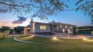 A modern two-story house with a well-maintained lawn, outdoor seating area, and a staircase leading to the entrance. - Charming family villa with pool in Pula (Pula)