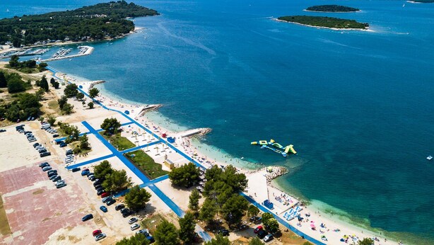An aerial view of a coastal area with a beach, parking lots, and a marina. - Charming family villa with pool in Pula (Pula)
