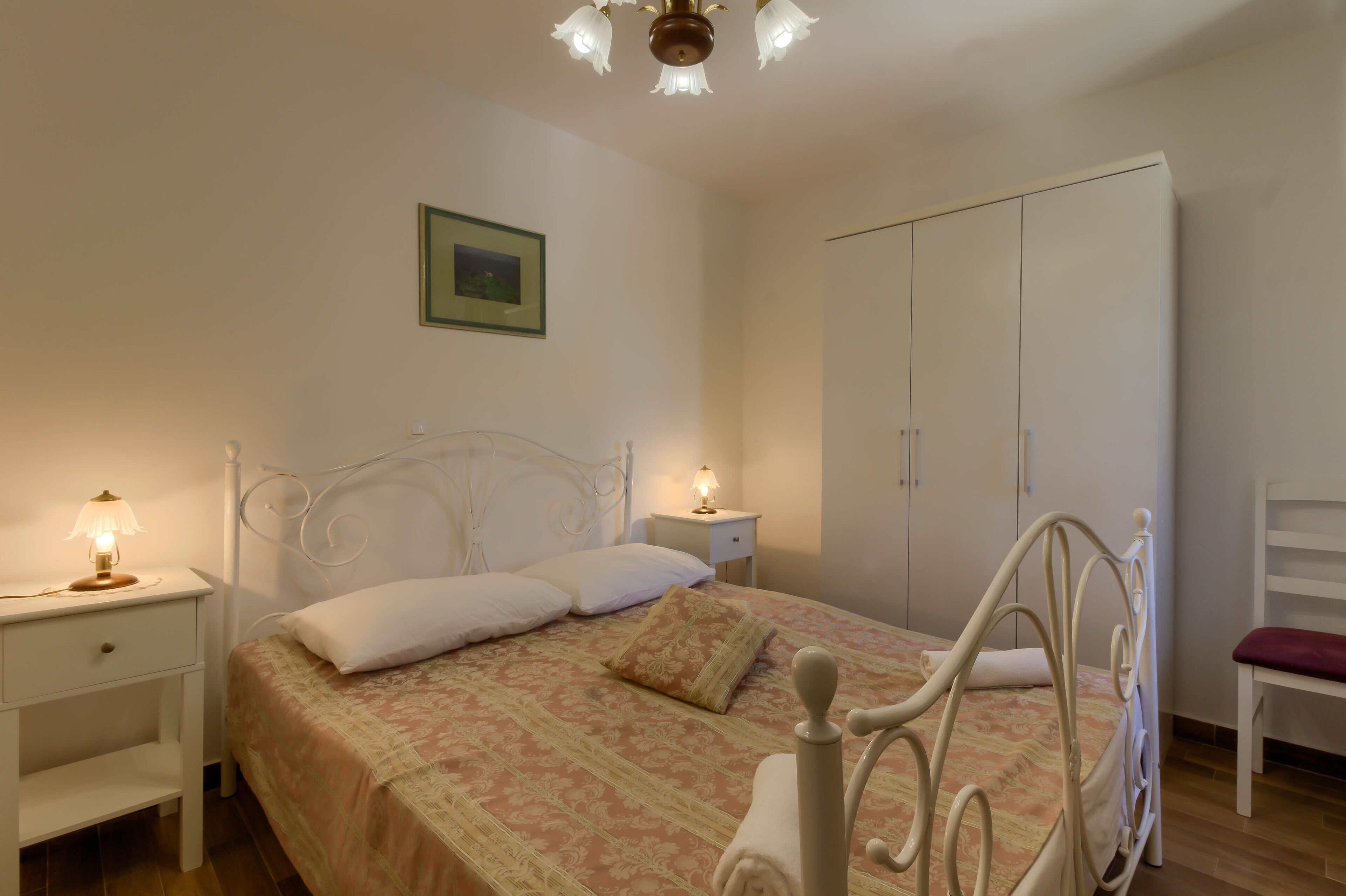 Une chambre à coucher comprenant un lit, des tables de chevet, une armoire et une chaise.