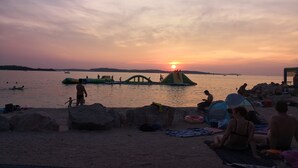 A beach scene with people relaxing and engaging in water activities.