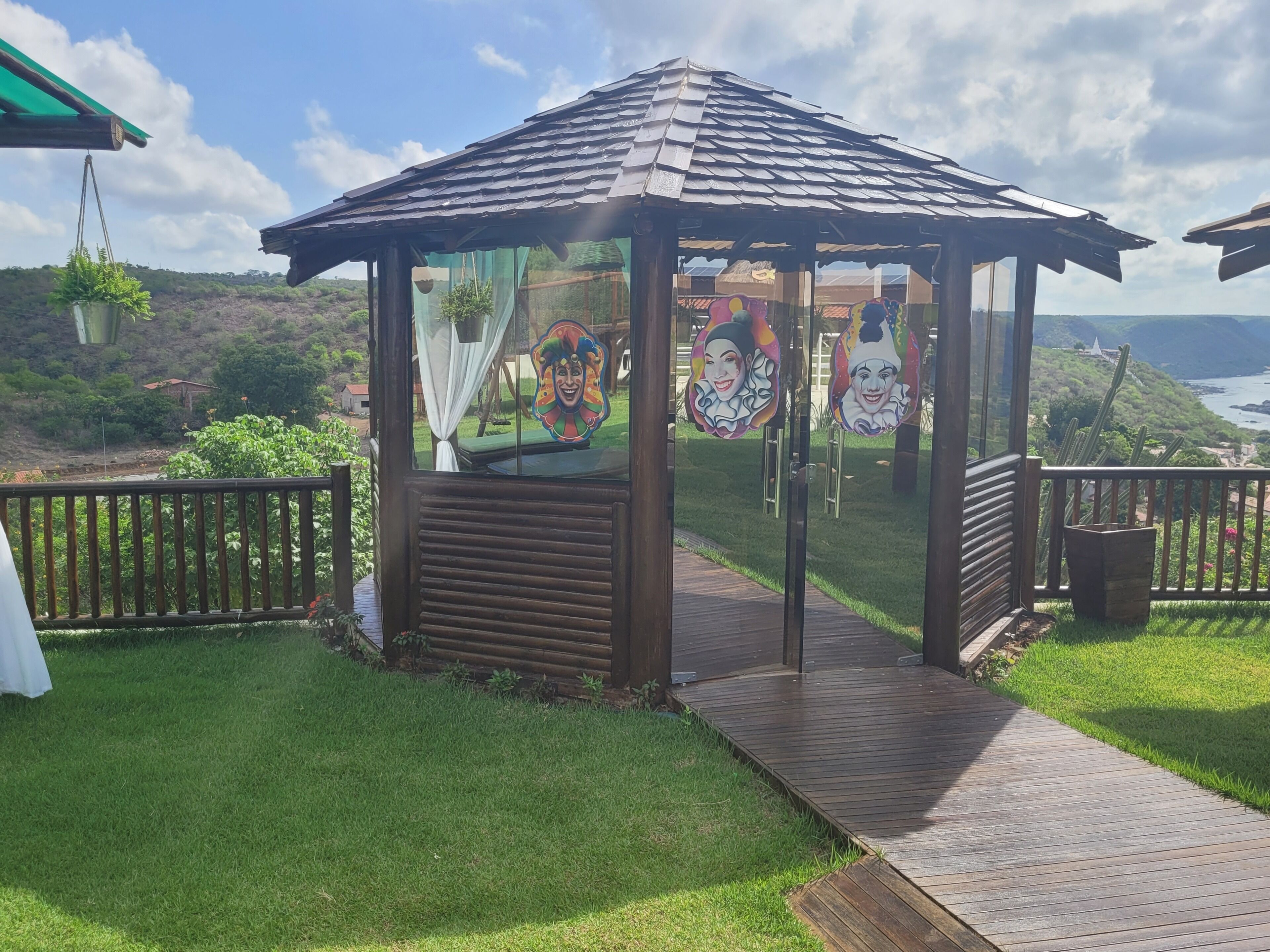 A gazebo with a view of the ocean and hills.