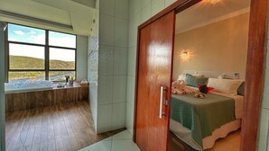 Un dormitorio con cama, mesita de noche y vista al río.