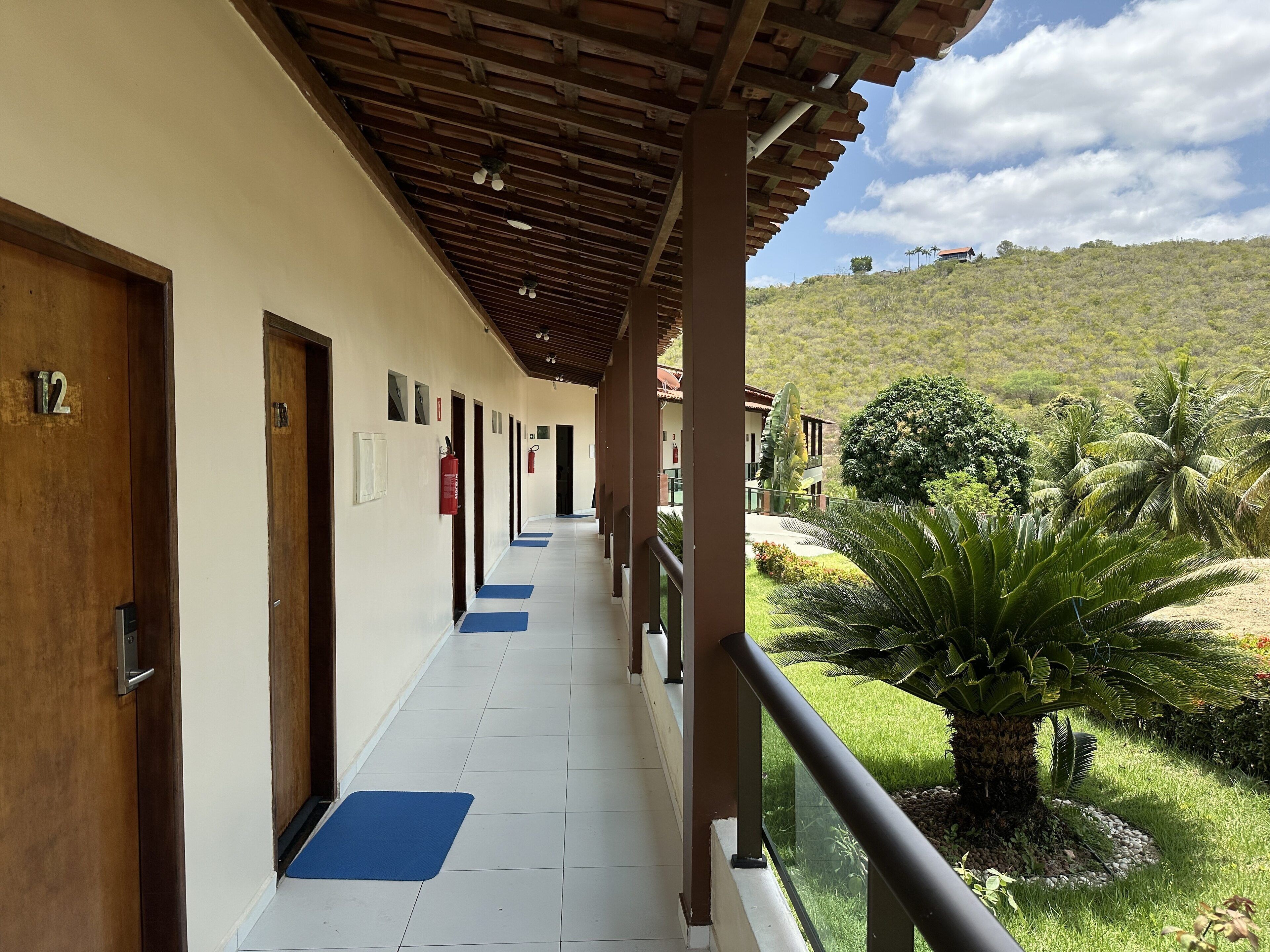 A corridor with doors numbered 12, 13, and 14, leading to rooms.