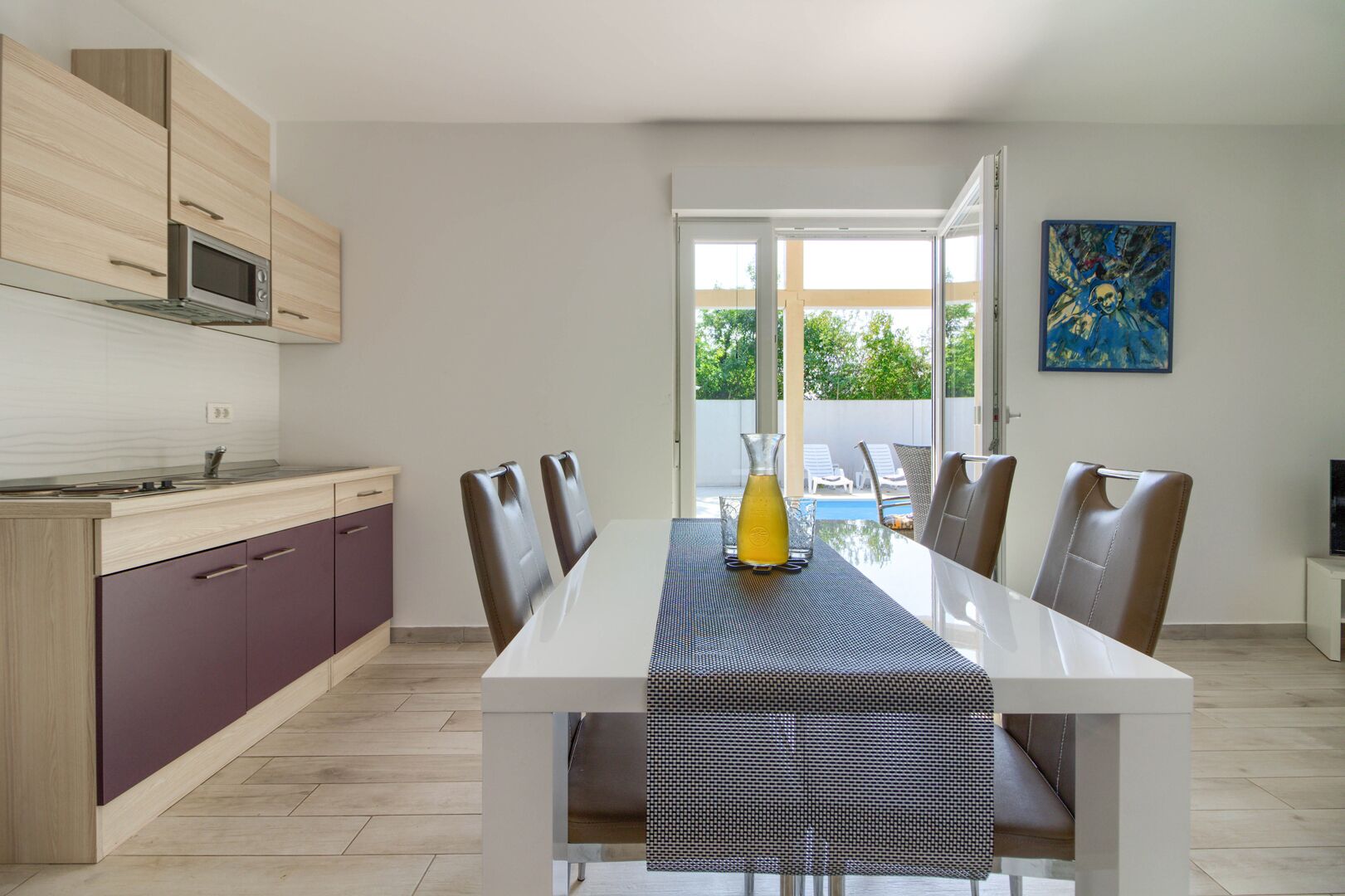 Una cocina moderna con comedor, un ventanal y vistas al exterior.