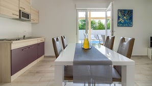 A modern kitchen with a dining area, a large window, and a view of the outdoors.