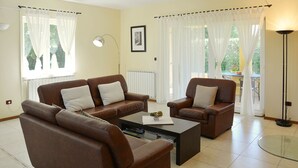 A living room with two brown sofas, a coffee table, and a glass table.