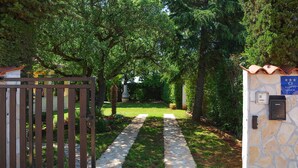 A gated entrance with a stone pathway leading to a building.