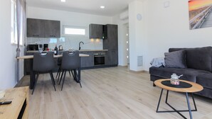 A modern living space with a kitchen, dining area, and a sofa. - Villa Relax (Istria - Sisan) (Sisan)