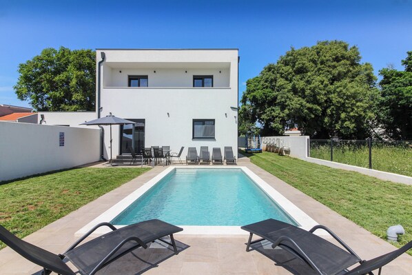 A modern two-story house with a swimming pool, outdoor seating, and a well-maintained lawn. - Villa RELAX II (Istria - Sisan) (Sisan)