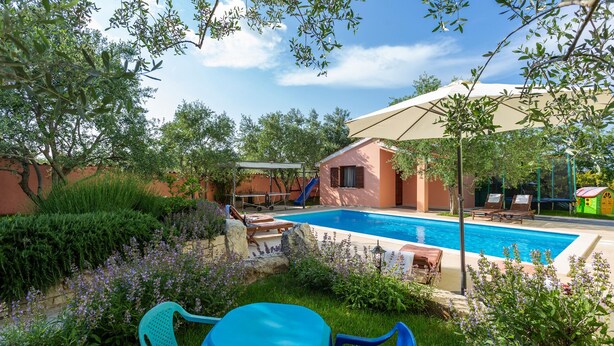 A pool area with a slide, lounge chairs, and a table. - Villa VERSOVICA (Istria - Peruški) (Peruški)