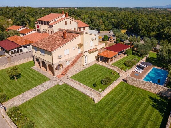 A large estate with multiple buildings, a swimming pool, and well-maintained lawns.