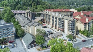 A multi-story hotel with a central courtyard, surrounded by lush greenery and hilly terrain. - Gatlinburg Ski Week! 2 Bedroom 2 Bath Full Kitchen Sleeps N6834 (Gatlinburg)