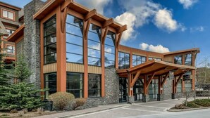 A modern building with large windows and a stone facade. - Vista Peak Hydeaway at Solara Resort (Canmore)