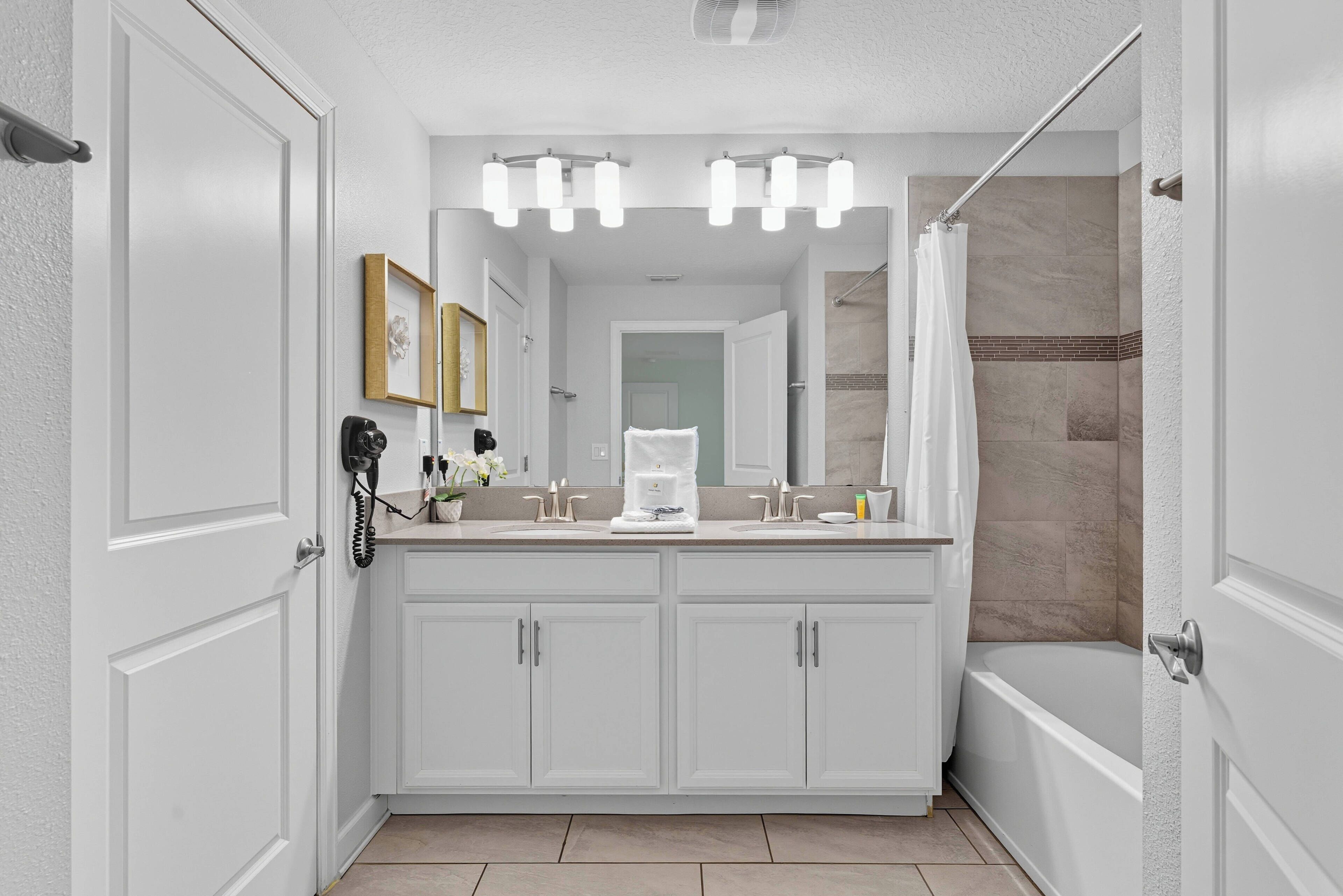 A modern bathroom with a large vanity, a shower, and a bathtub.