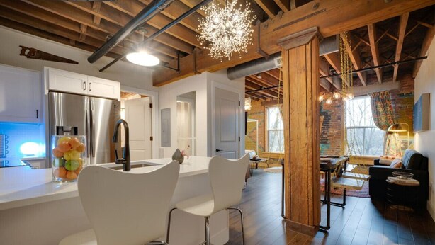 A modern kitchen with a central island, stainless steel appliances, and a hanging light fixture. - BRAND NEW! Vibrant & Exquisite -1 Mile to Downtown (Nashville)