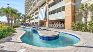 A hotel with a swimming pool, lounge chairs, and palm trees. - Mar Vista 1008 Direct Oceanfront in/outdoor pool (North Myrtle Beach)
