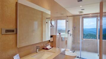 Un baño moderno con un espejo grande, un lavabo, una ducha y vistas al exterior.