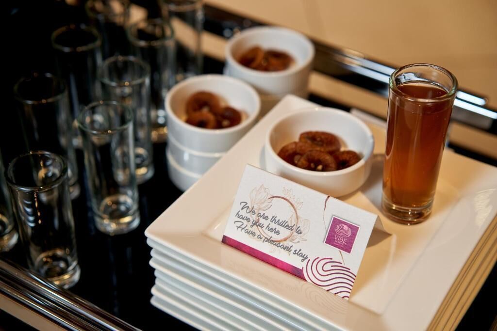 A tray with a glass of tea, small bowls of food, and a card with a message.