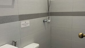 A bathroom with a toilet, sink, and shower. - Point F Siargao (General Luna)