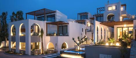 A modern multi-story house with a pool, arched windows, and a moonlit sky.