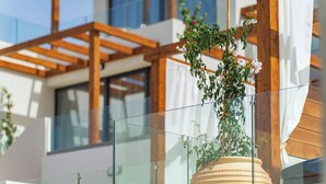 Un edificio moderno con balcón de cristal y vigas de madera.