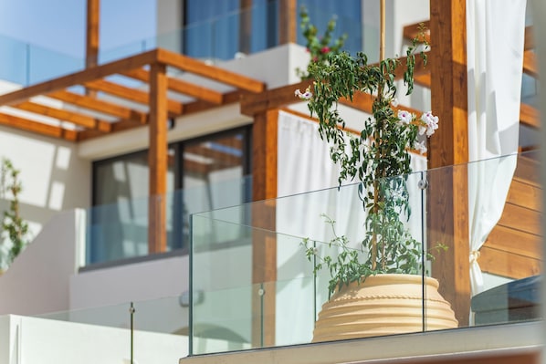 A modern building with a glass balcony and wooden beams. - Vaya Suites by Omilos Hotels (Malevizi)