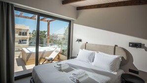 A modern hotel room with a large bed, a view of a rooftop jacuzzi, and a balcony with a chair.