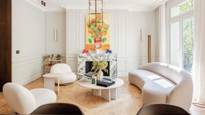 Un salon spacieux avec une cheminée, des murs blancs et une grande fenêtre.