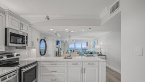 Una cocina moderna con armarios blancos, electrodomésticos de acero inoxidable y una isla grande.