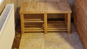 A bathroom with marble tiles, a wooden bench, and a radiator. - FeWo SN-Zippendorf with sauna, close to the beach and 4 km to the Citty (Schwerin)