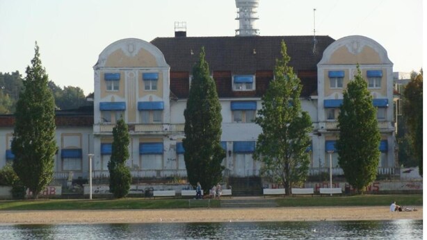 A multi-story building with a central tower, likely a hotel, featuring balconies and a waterfront view. - FeWo SN-Zippendorf with sauna, close to the beach and 4 km to the Citty (Schwerin)