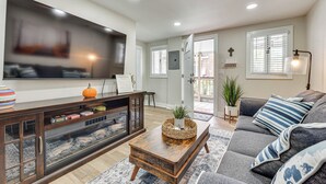 A living room with a TV, sofa, coffee table, and a fireplace. - Cozy Jacksonville Cottage, Walkable Location! (Jacksonville)