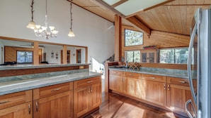 A spacious kitchen with wooden cabinets, granite countertops, and a stainless steel refrigerator. - Home 1 Mi to Downhill Ski Resort: Bring Your Pets! (Truckee)