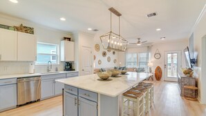 A spacious kitchen with a large island, white cabinetry, and a dishwasher. - Steps to Beach: Pet-friendly Crystal Beach Home (Port Bolivar)